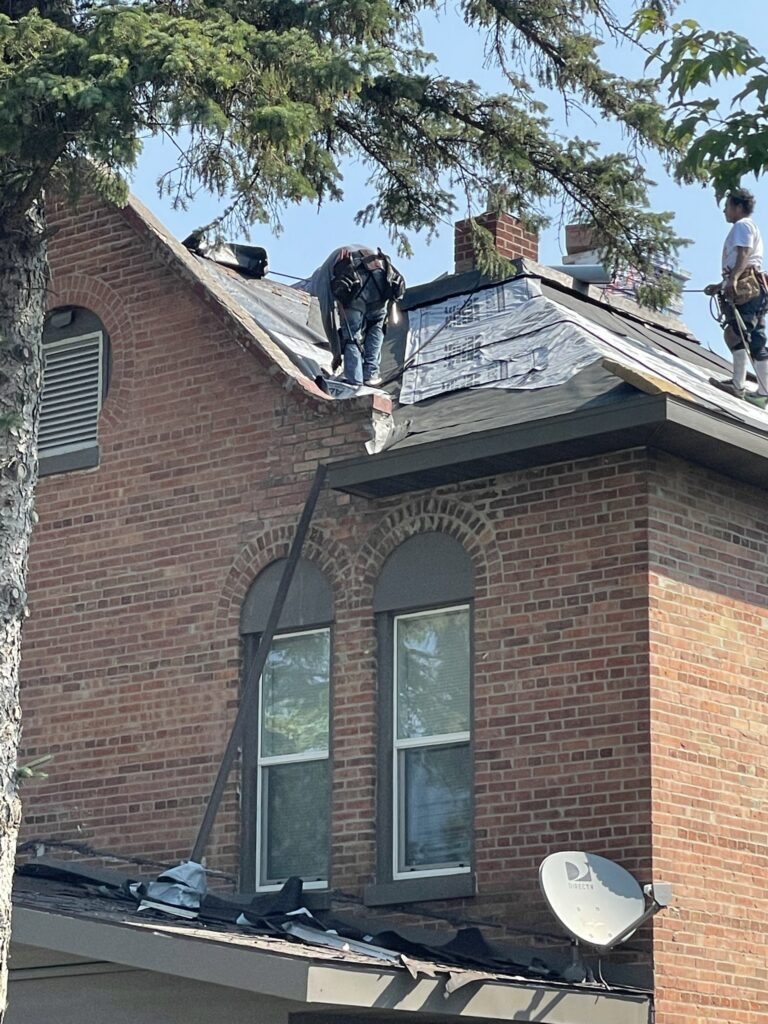 Historic home in Sauk Centre, MN being re-sheathed and reroofed with crew in safety harnesses